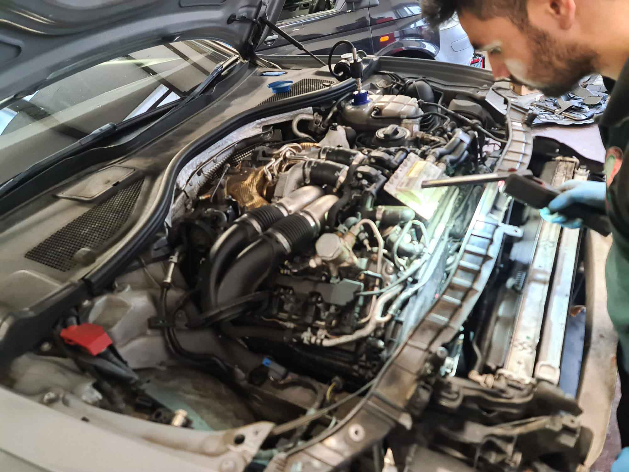Technician fault finding in an Audi engine bay