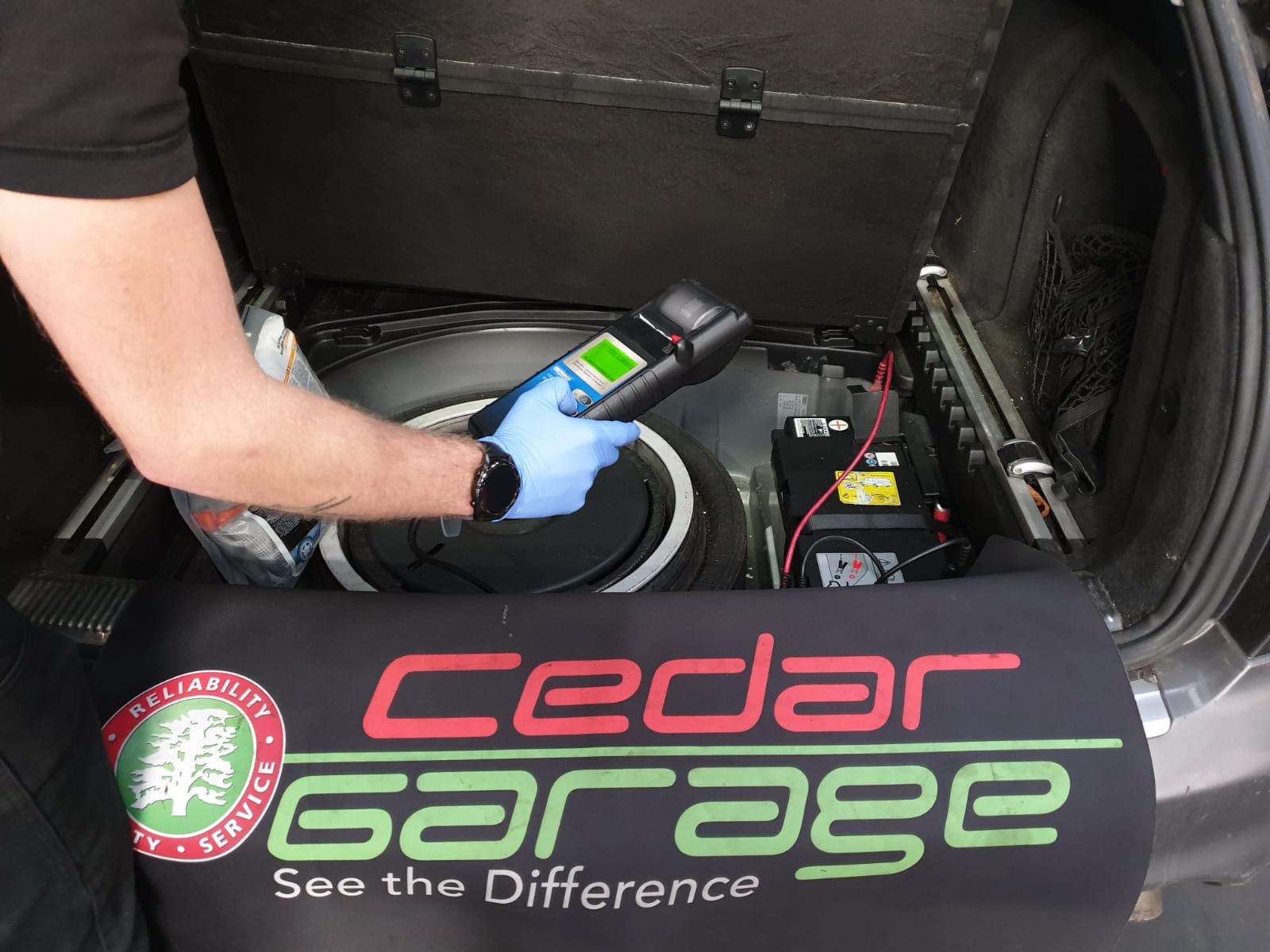 Technician carrying out a battery test on an Audi