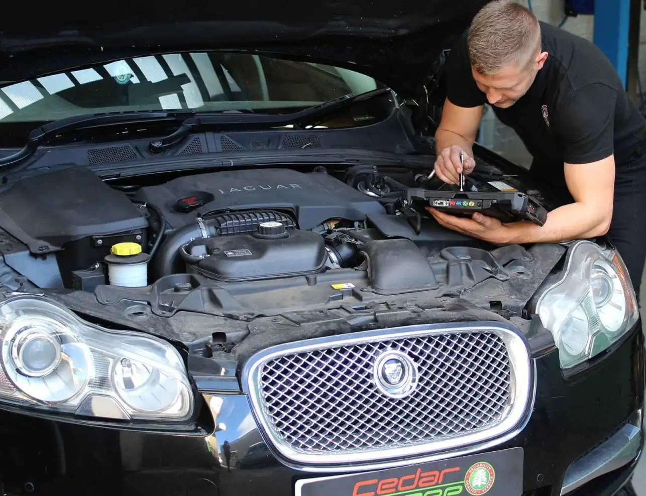 Jaguar Diagnostics Worthing Technician carrying out Jaguar diagnostics under the bonnet