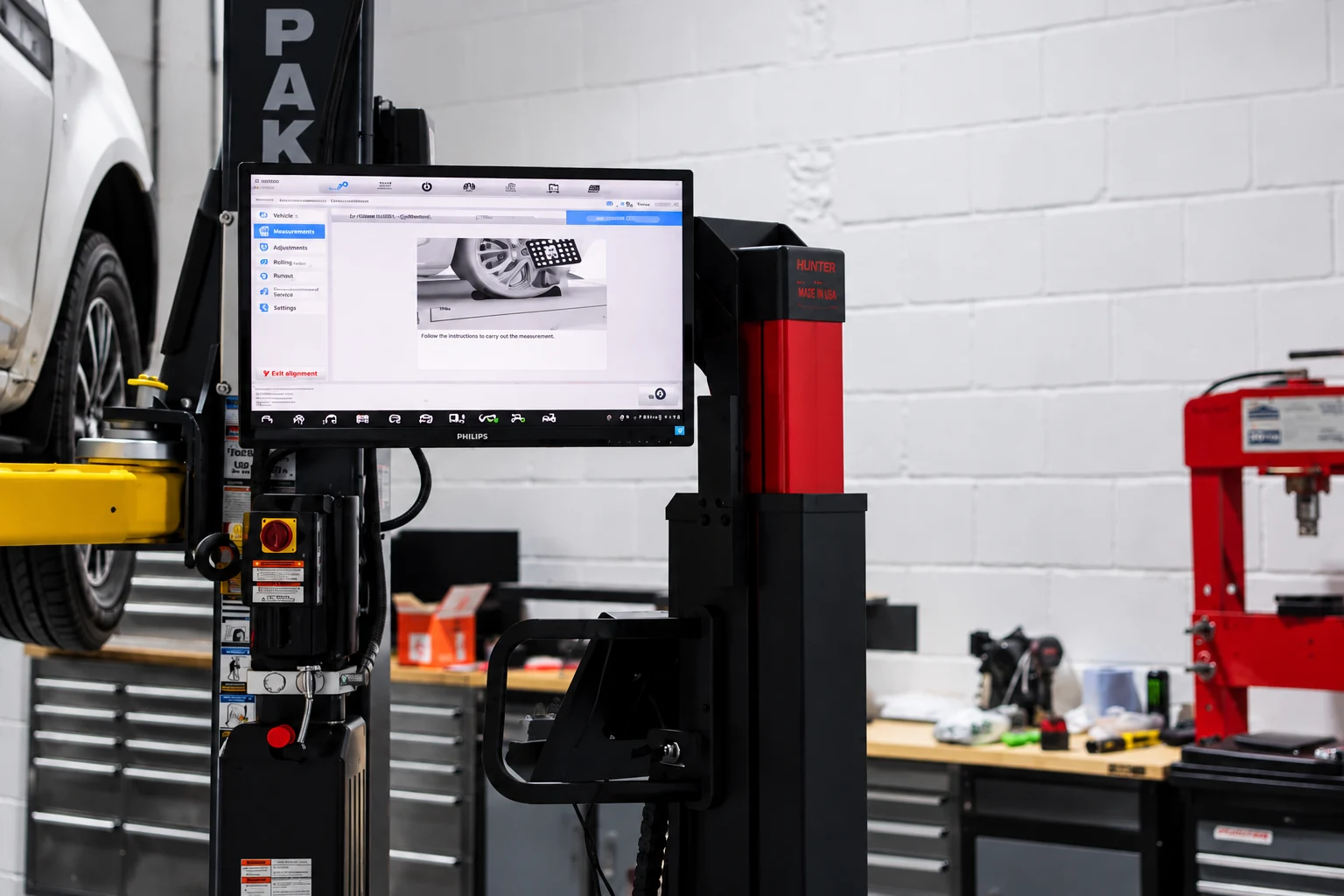 Wheel alignment equipment showing geometry readings on screen